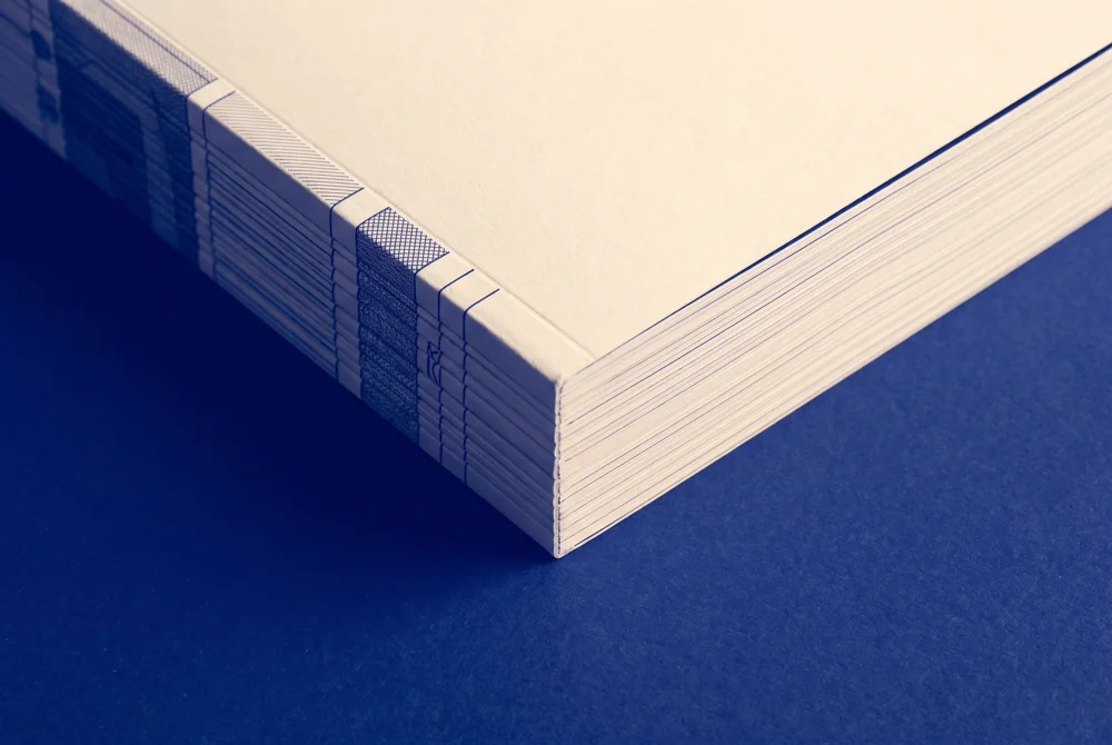 A bound founder packet on a cobalt surface
